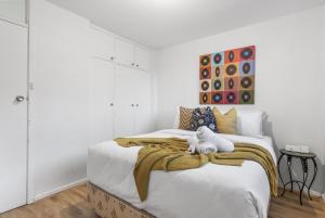 Un dormitorio con una cama con un osito de peluche. en EAST4 - Vintage Vibes East Freo 2B 1BA en Fremantle