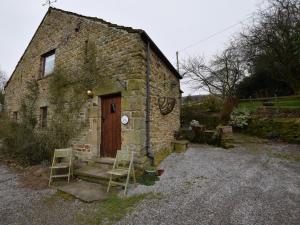 an old stone building with two chairs and a door at 2 Bed in Hope PK431 in Aston