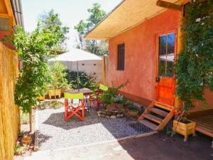eine Terrasse mit einem Tisch, Stühlen und einem Sonnenschirm in der Unterkunft Alojamiento Rural Casa Quinta Peumayen in Isla de Maipo