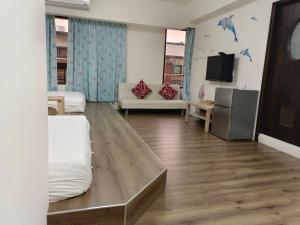 uma sala de estar com duas camas e uma televisão em 星之芳庭 潮州民宿 親子寵物友善 em Chaozhou