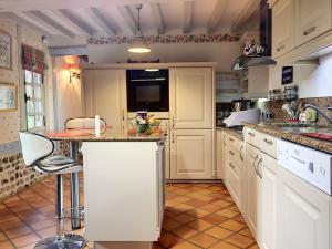 a kitchen with white cabinets and a counter top at 2 chaumieres pour vos Week-end et vacances en Normandie in Saint-Georges-du-Vièvre