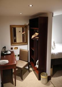 ロンドンにあるドリームテル ロンドン ケンジントンのデスク、ベッド、デスクが備わる客室です。