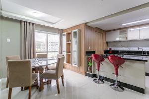 a kitchen with a dining table and red chairs at WI-FI 600mb | 500m da UFSC #TRINA02 in Florianópolis