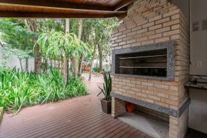 a brick wall with a fireplace in a patio at WI-FI 600mb | 500m da UFSC #TRINA02 in Florianópolis