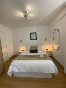 a bedroom with a large white bed and two mirrors at Apartamentos Oviedo centro apartastur26 in Oviedo
