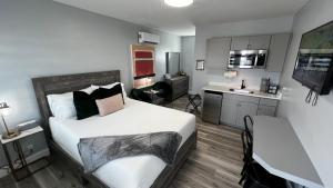 a small bedroom with a bed and a kitchen at Oceano Suites Daytona Beach in Daytona Beach