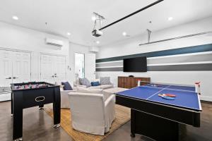 a living room with a ping pong table and a living room at Laguna Loafin' - Panama City Beach, FL in Panama City Beach