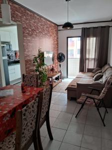 - un salon avec une table et un canapé dans l'établissement Apto Aconchegante, à Praia Grande