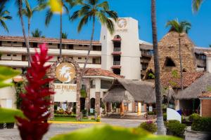 a hotel with palm trees in front of it at Las Palmas by the Sea All Inclusive in Puerto Vallarta