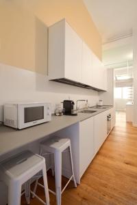 MILAN design Loft-Hosted by Sweetstay في ميلانو: مطبخ مع دواليب بيضاء وميكرويف