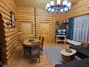 - un salon avec une table dans une cabane en rondins dans l'établissement Cabana Alesia, relaxare la poalele Raraului, à Câmpulung Moldovenesc