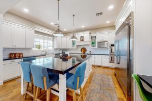 a kitchen with white cabinets and blue chairs at Queen Creek Oasis in Queen Creek