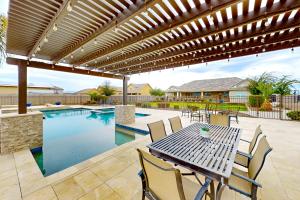 a patio with a table and chairs and a swimming pool at Queen Creek Oasis in Queen Creek