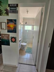 uma casa de banho com um WC, um lavatório e uma porta em Bertioga Praia do SESC - Apartamento de 2 quartos em Bertioga