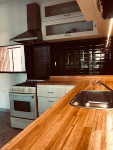 a kitchen with a wooden counter top and a sink at Pecan in Concepción del Uruguay