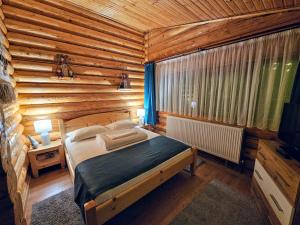 a bedroom with a bed in a log cabin at Cabana Alesia, relaxare la poalele Raraului in Câmpulung Moldovenesc