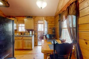 a kitchen with wooden walls and a wooden table in a cabin at Pine Tree Lodge in Sautee Nacoochee