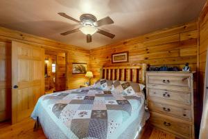 a bedroom with a bed and a ceiling fan at Pine Tree Lodge in Sautee Nacoochee