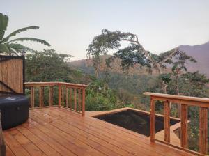 une terrasse en bois avec vue sur les montagnes dans l'établissement hotel y restaurante mirador aires de la sierra, minca, à Minca