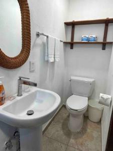 a bathroom with a sink and a toilet and a mirror at 15 - 139 D Beautiful Dept in Los Tules in Puerto Vallarta