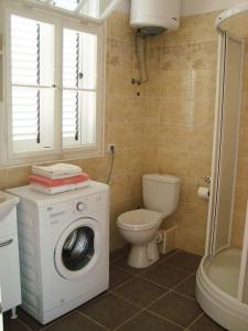 a bathroom with a washing machine and a toilet at Apartments Rolovina in Tivat +82 photos
