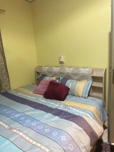 a bed with two pillows on it in a room at Chez nous in Madina