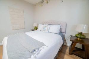 1 dormitorio con 1 cama blanca grande y 2 lámparas en Ping Pong, A/C, Netflix, Grill, Jacuzzi Tub, W/D en Placentia