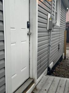 una puerta blanca en una casa con porche en Little house on 47th, en Cleveland