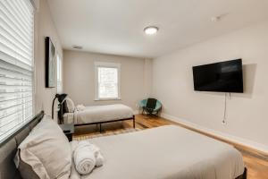 1 Schlafzimmer mit 2 Betten und einem Flachbild-TV in der Unterkunft Spacious East Orange Home Steps to Elmwood Park! in East Orange