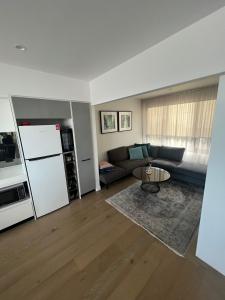 ein Wohnzimmer mit einem Sofa und einem Kühlschrank in der Unterkunft Ruckers Hill Northcote Penthouse in Melbourne