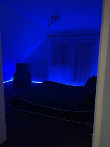 Habitación azul con cama y silla en Soukroma ložnice s terasou a pracovnou, en Praga
