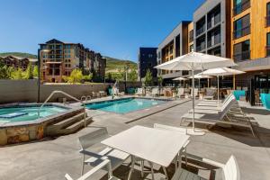 a pool with tables and chairs next to a building at Canyons Resort #134 in Park City