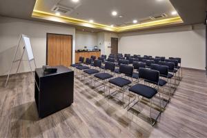 a conference room with a row of chairs and a podium at City Express Plus by Marriott Interlomas in Mexico City