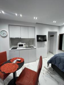 eine Küche mit einem Tisch und eine Küche mit weißen Schränken in der Unterkunft Midnight Apartments in Tirana