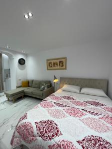 Schlafzimmer mit einem Bett mit einer roten und weißen Decke in der Unterkunft Midnight Apartments in Tirana