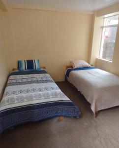 dos camas sentadas una al lado de la otra en una habitación en killa andina inn, en Puno