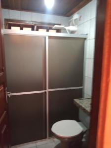a bathroom with a toilet and a shower stall at Casa de Porto de Galinhas 137 in Porto De Galinhas