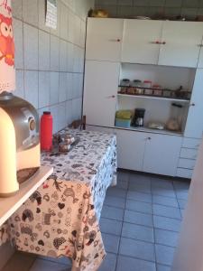 a kitchen with white cabinets and a table in a room at Casa de Porto de Galinhas 137 in Porto De Galinhas