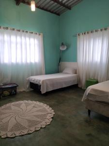 a bedroom with two beds and a window with curtains at Casa confortável, pertinho da cidade e conectada a natureza in Brasília