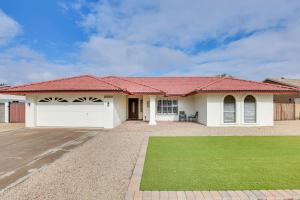 a white house with a red roof at 8 Mi to State Farm Stadium Home with Pool in Peoria