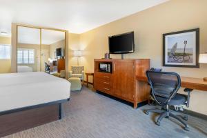 Habitación de hotel con cama, escritorio y TV. en Best Western Plus Beach View Lodge en Carlsbad