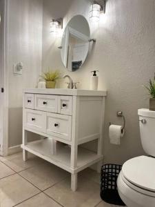a white bathroom with a sink and a toilet at House Close to Downtown, Airport, Raymond James Stadium, and Many More Places in Tampa