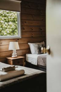 a bedroom with two beds and a window at Tatahi Lodge Beach Resort in Hahei