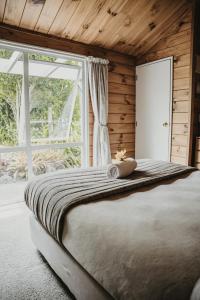 sypialnia z dużym łóżkiem i oknem w obiekcie Tatahi Lodge Beach Resort w mieście Hahei