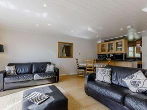 uma sala de estar com mobiliário de couro preto e uma cozinha em 3 Bed in Cirencester HIC02 em South Cerney