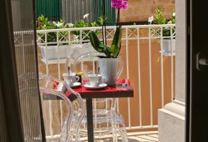 a table with two chairs and a potted plant on a balcony at Principe Relais Suite & Spa in Gravina in Puglia