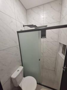 a white bathroom with a toilet and a shower at Loft B Hospedagem Cidade Verde B in Maringá