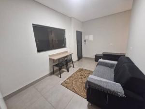 a living room with a couch and a flat screen tv at Loft B Hospedagem Cidade Verde B in Maringá