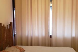 een slaapkamer met een bed en een raam met gordijnen bij Flecheiras Eco Residence Un302 in Flecheiras