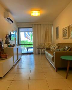 ein Wohnzimmer mit einem Sofa und einem Tisch in der Unterkunft Nannai Residence, Beira-mar - Porto de Galinhas / Muro Alto (BDJ06) in Porto De Galinhas
